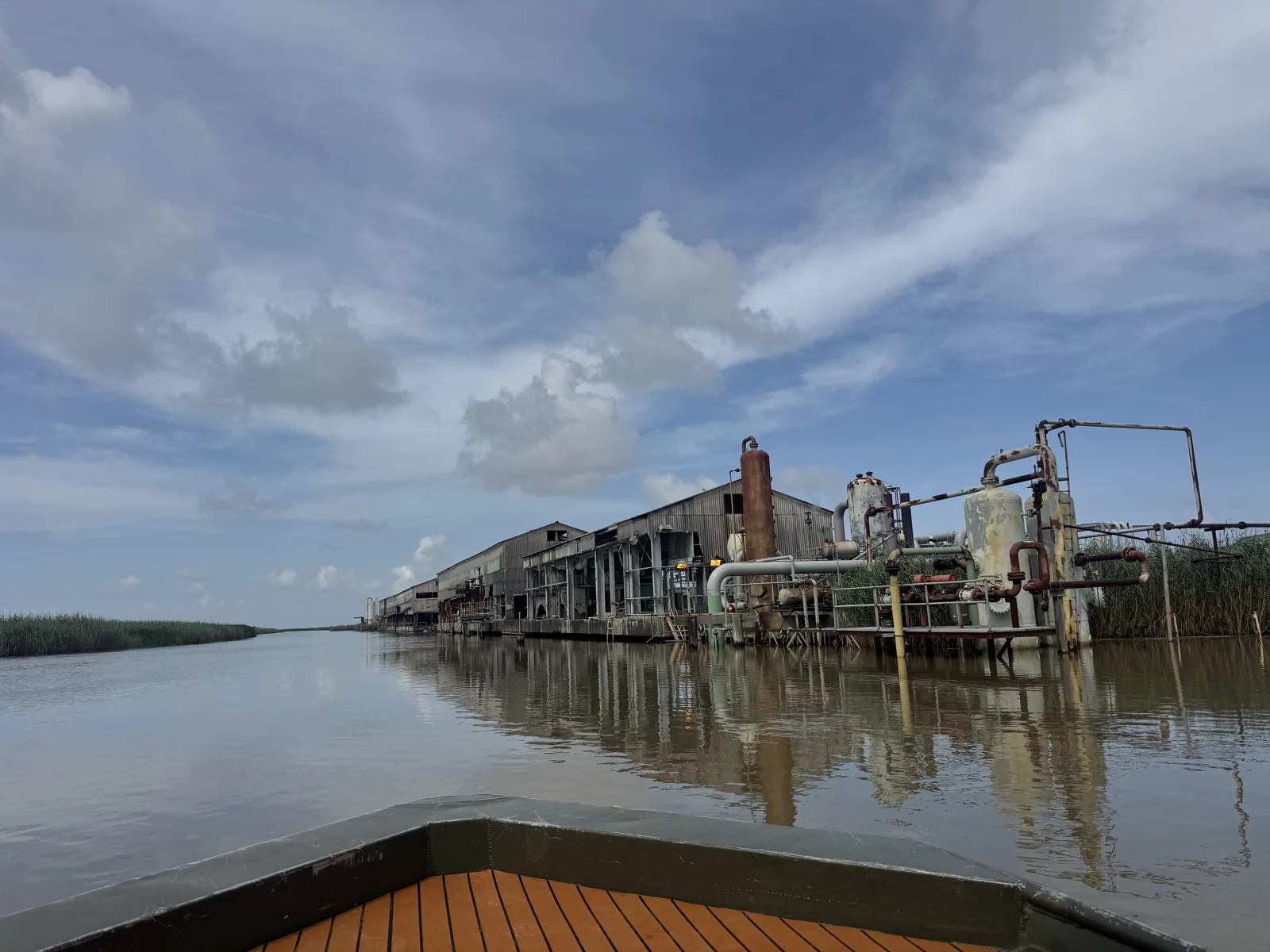 Oil and gas infrastructure seen across a waterway in the Mississippi River Delta