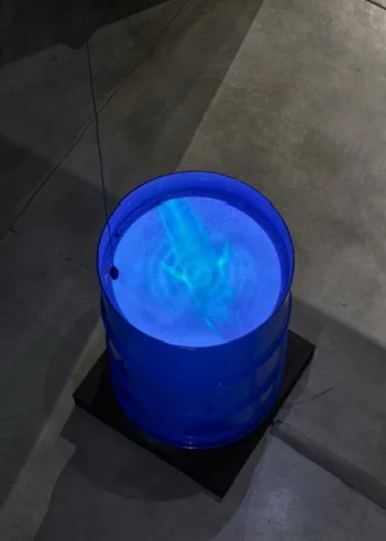 Overhead view of the blue installation basin, with the whale projected through the water